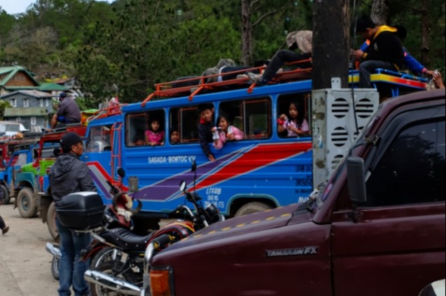 Kids blowing bubbles while playing in a jeepney
